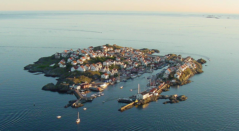 Deltagare i Ribtours-overaller som tävlar i en trekamp på en skärgårdsö medan en Ribtours RIB-båt ligger i närheten.